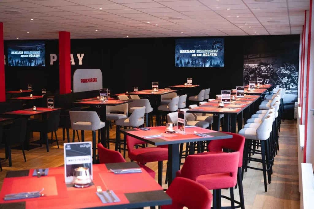 Tischreihen im VIP-Bereich vor der Wand mit dem Schriftzug Power Play
